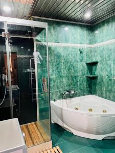 a bath tub in a bathroom with green tiles at Superb Central Location! Spacious and Comfortable 1 Bedroom + Jacuzzi, Next To Northern Avenue in Yerevan