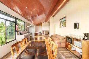 uma cozinha e sala de estar com uma mesa de madeira e cadeiras em Monteverde Ecolove em Monteverde