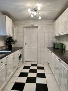 a kitchen with a black and white checkered floor at Holiday Home in Walthamstow in London