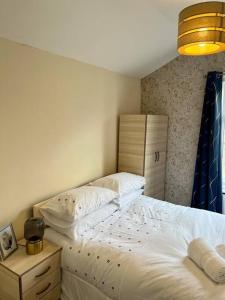 a bedroom with a bed and a dresser and a lamp at Holiday Home in Walthamstow in London