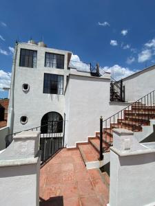 a white building with stairs and a balcony at Casa Laberinto in San Miguel de Allende