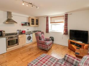 sala de estar con 2 sillas y cocina en Flat 8 en Bridlington