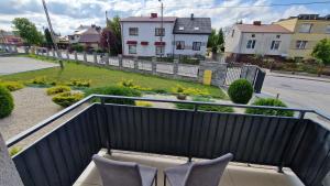 a balcony with two chairs and a view of a yard at Apartament Gimnazjalna Prestige in Końskie