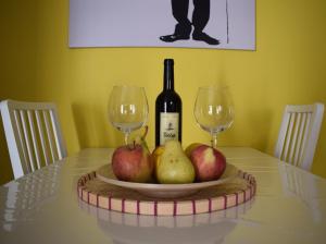 a table with a plate of apples and a bottle of wine at El Charco Azul in San Andres y Sauces