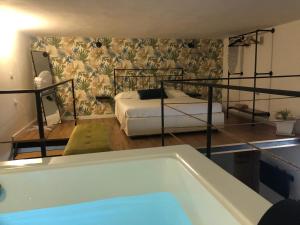 a bathroom with a tub and a bed and a tub at Vecchio Loft con Jacuzzi in Siracusa