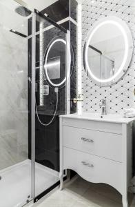 uma casa de banho com um chuveiro, um lavatório e um espelho. em Danube Royal de Lux em Budapeste