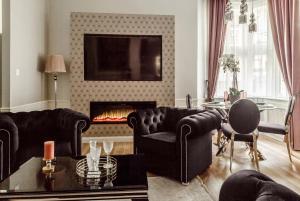 uma sala de estar com mobiliário preto e uma lareira em Danube Royal de Lux em Budapeste