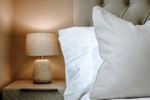 a bed with a pillow and a lamp on a night stand at Spring Grove Apartment - Central Harrogate in Harrogate