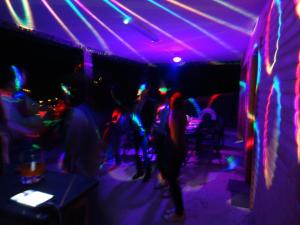 grupa ludzi tańczących w pokoju ze światłami w obiekcie Cabana Deac - Luxury Chalet w mieście Vatra Dornei