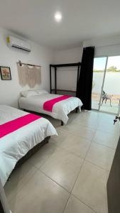 two beds in a bedroom with a view of the ocean at Casa de Descanso y Aventuras en zona privada in Mérida