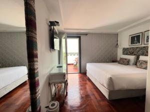 - une chambre avec 2 lits et une porte coulissante en verre dans l'établissement La Casa del Viajero, à Lima