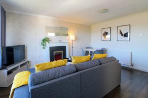 a living room with a couch and a tv at Airport Way - Cosy 2 Bed Apartment near the M1 in Luton
