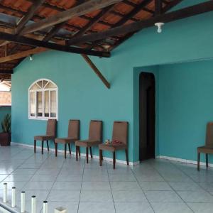 uma fila de cadeiras num quarto com uma parede azul em Casa Verde em Joinville