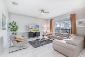 a living room with a couch and a tv at Luxury Home inside Champions Gate - No Extra Fees in Davenport
