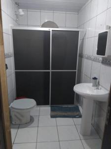 a bathroom with a shower and a toilet and a sink at Casa Verde in Joinville