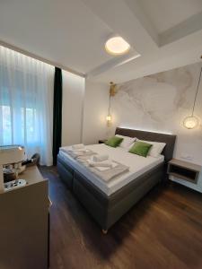 a bedroom with a large bed with green pillows at Rooms Lidija in Zagreb