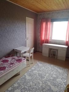 1 dormitorio con cama, escritorio y ventana en Vanha maalaistila, en Kuhmo