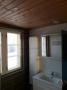 baño con lavabo, espejo y ventana en Vanha maalaistila, en Kuhmo