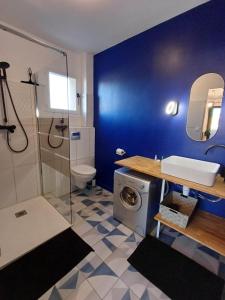 a bathroom with a washing machine and a blue wall at Studio très agréable avec balcon et Wi-Fi in Sanary-sur-Mer