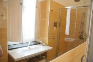 y baño con lavabo y ducha. en Palazzo della Poesia Casa Vacanze, en Salerno