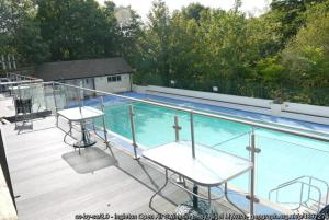 a balcony with a swimming pool and two tables at Marian Cottage in Ingleton