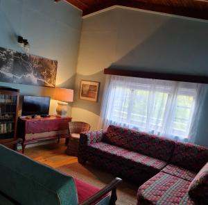 sala de estar con sofá y TV en Stok&Hoed en Natureʼs Valley