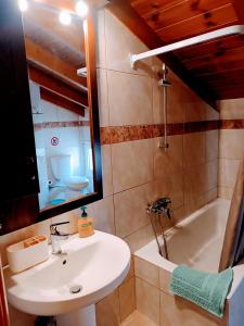 a bathroom with a sink and a bath tub at Hermione Port Luxury Residence in Ermioni