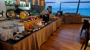 a bar with a long counter with plates and drinks at Design Suites Calafate in El Calafate