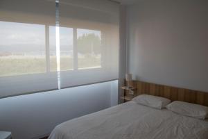 1 dormitorio con cama y ventana en Apartamento de Mar y Playa en Illa de Arousa, en A Illa de Arousa