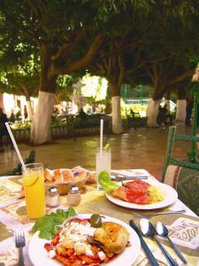 a table with plates of food and drinks on it at Hotel Posada Santa Fe in Guanajuato