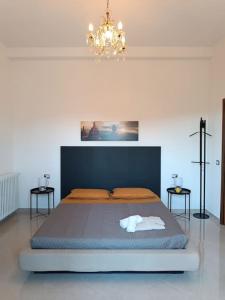 Un dormitorio con una cama grande y una lámpara de araña. en B&B IL TULIPANO en Como