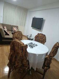ein Wohnzimmer mit einem Tisch, Stühlen und einem Sofa in der Unterkunft Apartamentos Cristo Rey. in Tacna