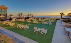 een groep stoelen en tafels op een gazon bij Marriott Virginia Beach Oceanfront Resort in Virginia Beach