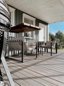 een patio met een tafel en stoelen op een veranda bij HYGGE Sauna&Fishing House 