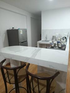 a kitchen with a white table and two chairs at Apartamentos Cristo Rey. in Tacna