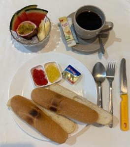 een wit bord met een broodje en een kopje koffie bij Samui Zenity in Mae Nam