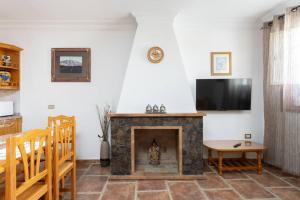 sala de estar con chimenea y TV de pantalla plana en El Retamar, naturaleza y paisajes en Santiago del Teide