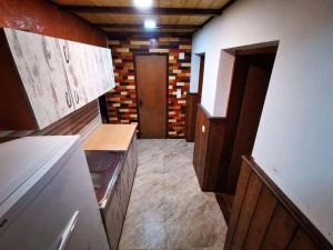 a small kitchen with wooden cabinets and a door at Vila Treska 98 in Kopaonik