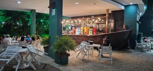 a restaurant with a bar with people sitting at tables at Angra inn Ap quarto e sala (temporadas) in Angra dos Reis