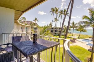 a table on a balcony with a view of the ocean at Sunny Waianae Condo with Ocean View! in Waianae