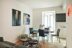 Una sala de estar con un sofá, una mesa y sillas. en Remarkable flat in the historical part of Beziers, en Béziers