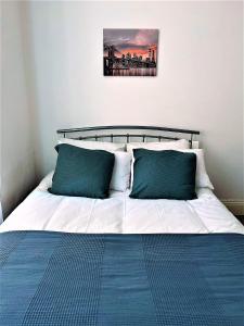 a bed with two green pillows on top of it at Trendy Town house - Room 1 in Parkside