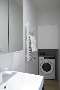 baño blanco con lavadora y lavamanos en Remarkable flat in the historical part of Beziers, en Béziers