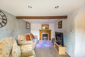 a living room with a couch and a tv at Pendre Cottage in Llanfyrnach