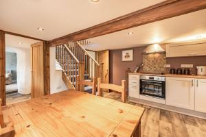 eine Küche mit einem Holztisch im Zimmer in der Unterkunft Pendre Cottage in Llanfyrnach