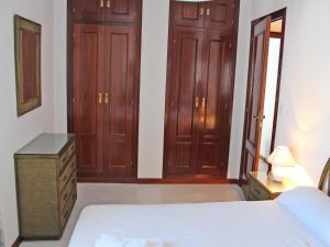 コニル・デ・ラ・フロンテーラにあるApartamento Mercedesのベッドルーム1室(木製キャビネット、ベッド1台、ドレッサー付)