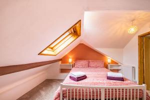a attic bedroom with a bed with two pillows on it at Pendre Cottage in Llanfyrnach