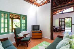 un soggiorno con un divano e una TV di itamambuca condominio - Cabana Surf a Ubatuba