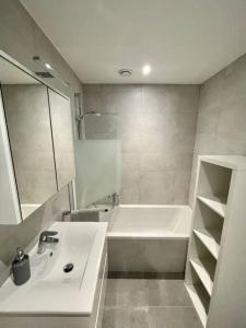 biała łazienka z umywalką i wanną w obiekcie Brand New 3 bedrooms with Terrace and Parking - 142-92 w Luksemburgu