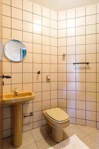 un bagno con un water, un lavandino e uno specchio di itamambuca condominio - Cabana Surf a Ubatuba Altre 51 foto